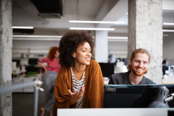 Frau und Mann am Computer diskutieren Führungskompetenz